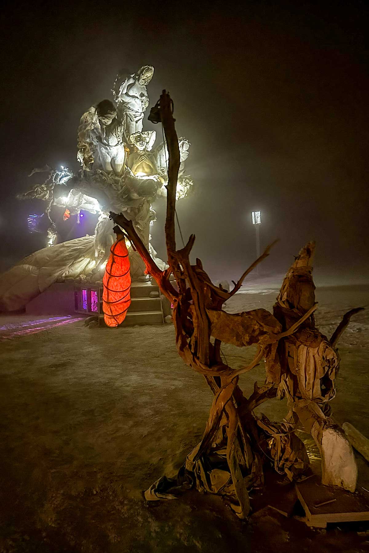 Womantree at night through dusty haze, with a red lantern and twisted branches in the foreground
