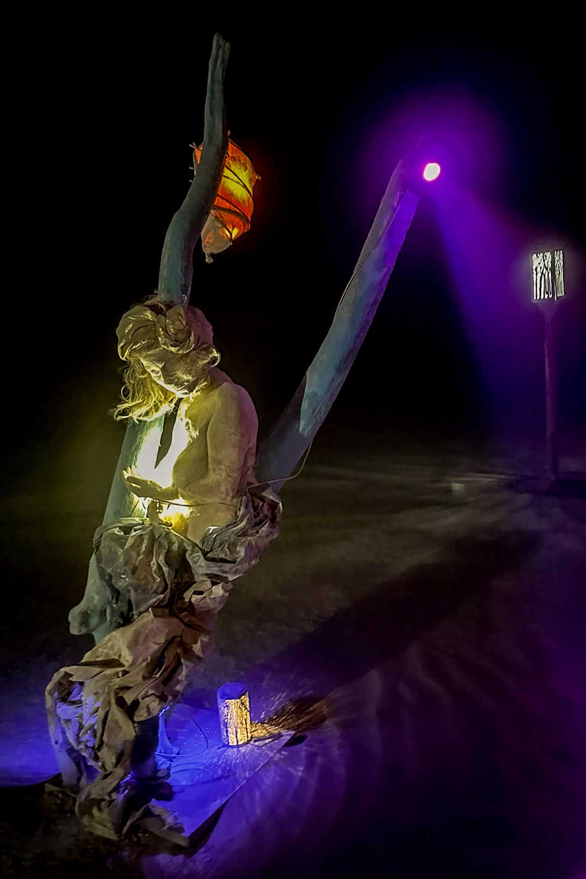 Swing figure at night against a dark sky, with a purple spotlight and a red lantern