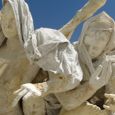 Two cast figures of women bowing and reaching out